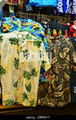 Bunte hawaiianische Hemden hängen auf einem Regal zum Verkauf an einem Marktstand und einem kleinen Geschäft in der Nähe von Waikiki Beach in Honolulu, Hawaii Stockfoto