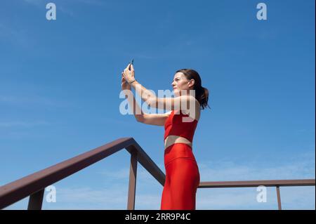 Sportliche Frau, die ein Selfie auf ihrem Handy macht, Outdoor-Fitnesskonzept. Stockfoto