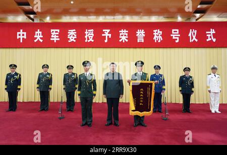 210705 -- PEKING, 5. Juli 2021 -- Xi Jinping, Vorsitzender der Zentralen Militärkommission CMC, überreicht eine Ehrenflagge an Vertreter einer Sondereinsatzgeschwader der Einheit der bewaffneten Volkspolizei in der Autonomen Region Xinjiang Uygur, und posiert für ein Gruppenfoto mit ihnen bei einer Zeremonie, die vom CMC in Peking, der Hauptstadt Chinas, am 5. Juli 2021 abgehalten wird. Das Geschwader aus Xinjiang erhielt den Titel Anti-Terror Sharp Knife Squadron für seine herausragende Leistung im Kampf gegen den Terrorismus. CHINA-PEKING-XI JINPING-EHRENTITEL-XINJIANG ANTI-TERROR-GESCHWADER CN LIXGANG PUBLICATIONX Stockfoto