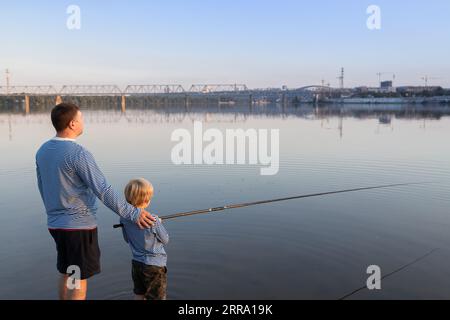 Vater und Sohn gehen zusammen angeln. Das Konzept des Vatertags. Familienspaß für das Wochenende. Gemeinsames Hobby für Kind und Eltern. Sei wie Papa. Verantwortungsbewusster Paren Stockfoto