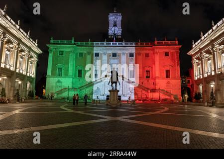 Senatorialpalast (Palazzo Senatorio) leuchtet nachts in den Farben Italiens auf der Piazza del Campidoglio auf dem Kapitolshügel in Rom, Italien. Stockfoto