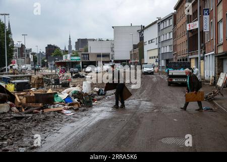 210716 -- VERVIERS BELGIEN, 16. Juli 2021 -- Menschen werfen zerbrochene Möbel nach Überschwemmungen in Verviers, Belgien, 16. Juli 2021 weg. Belgien hat den 20. Juli zu einem nationalen Tag der Trauer über die Opfer des Unwetters der letzten Tage erklärt. 21 Menschen starben und 18 wurden am Freitag nach Sturzfluten vermisst, bei denen Flüsse ihre Ufer im Süden und Osten des Landes platzen sahen. BELGIEN-VERVIERS-FLOOD-AFTERMATH ZhangxCheng PUBLICATIONxNOTxINxCHN Stockfoto