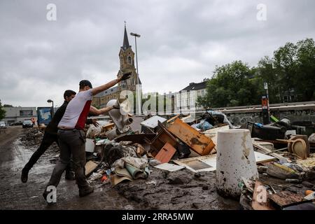 210716 -- VERVIERS BELGIEN, 16. Juli 2021 -- Menschen werfen zerbrochene Möbel nach Überschwemmungen in Verviers, Belgien, 16. Juli 2021 weg. Belgien hat den 20. Juli zu einem nationalen Tag der Trauer über die Opfer des Unwetters der letzten Tage erklärt. 21 Menschen starben und 18 wurden am Freitag nach Sturzfluten vermisst, bei denen Flüsse ihre Ufer im Süden und Osten des Landes platzen sahen. BELGIEN-VERVIERS-FLOOD-AFTERMATH ZhangxCheng PUBLICATIONxNOTxINxCHN Stockfoto