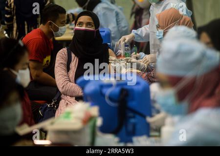 210717 -- TANGERANG, 17. Juli 2021 -- Eine Frau erhält eine Dosis COVID-19-Impfstoff während einer Massenimpfungskampagne im Ciledug Youth Sport Center in Tangerang, Indonesien, 17. Juli 2021. Aufgrund des Anstiegs der COVID-19-Fälle in den letzten Tagen im Land hat Indonesien das Impfprogramm gegen die anhaltende Coronavirus-Krankheit aufgestockt. INDONESIEN-TANGERANG-COVID-19-IMPFUNG AGUNGXKUNCAHYAXB. PUBLICATIONxNOTxINxCHN Stockfoto