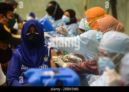 210717 -- TANGERANG, 17. Juli 2021 -- Eine Frau erhält eine Dosis COVID-19-Impfstoff während einer Massenimpfungskampagne im Ciledug Youth Sport Center in Tangerang, Indonesien, 17. Juli 2021. Aufgrund des Anstiegs der COVID-19-Fälle in den letzten Tagen im Land hat Indonesien das Impfprogramm gegen die anhaltende Coronavirus-Krankheit aufgestockt. INDONESIEN-TANGERANG-COVID-19-IMPFUNG AGUNGXKUNCAHYAXB. PUBLICATIONxNOTxINxCHN Stockfoto