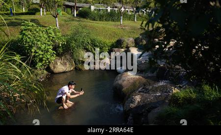 210717 -- JINGDEZHEN, 17. Juli 2021 -- Cheng Xiaoqian macht Fotos von Outdoor-Szene für künstlerische Kreation an einem malerischen Ort in Jingdezhen, Ostchinesische Provinz Jiangxi, 14. Juli 2021. Guyacai, wörtlich übersetzt „malerische Farbdekoration“ auf Chinesisch, ist eine Art Porzellandekoration, die in den 1980er Jahren erfunden wurde Seine Spezialität liegt in einer Kombination aus chinesischer Kunst und westlichen Gemälden. Ein Guyacai-Maler muss nicht nur gut über Pigmentmerkmale Bescheid wissen, sondern auch die Fähigkeiten in westlicher und traditioneller chinesischer Malerei, Kalligraphie und Dichtung beherrschen, um die Schönheit des Klassikers und der Schrulligkeit auszudrücken Stockfoto