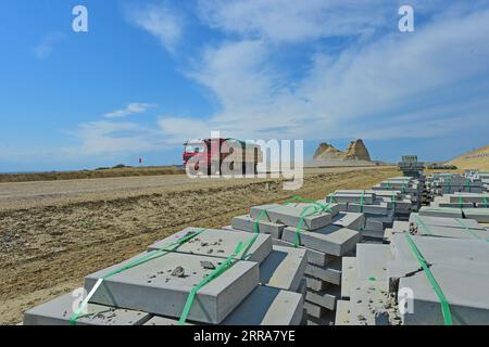 210720 -- FUHAI, 20. Juli 2021 -- Ein Lkw transportiert Baumaterialien auf eine Baustelle einer Schnellstraße durch die Wüste in der nordwestlichen chinesischen autonomen Region Xinjiang Uygur, 16. Juli 2021. Der Bau der ersten Schnellstraße über die Wüste in Xinjiang verlief reibungslos. Die Schnellstraße, die die Präfektur Altay mit der regionalen Hauptstadt Ürümqi verbindet, erstreckt sich über etwa 343 km, wobei Abschnitte von mehr als 150 km durch die Wüste gebaut werden. CHINA-XINJIANG-CROSS-DESERT EXPRESSWAY-BAU CN HOUXZHAOKANG PUBLICATIONXNOTXINXCHN Stockfoto