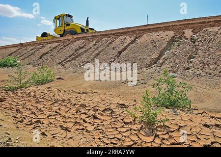 210720 -- FUHAI, 20. Juli 2021 -- Ein Fahrzeug ebnet einen Abschnitt einer Schnellstraße durch die Wüste mit Asphalt in der nordwestchinesischen autonomen Region Xinjiang Uygur, 16. Juli 2021. Der Bau der ersten Schnellstraße über die Wüste in Xinjiang verlief reibungslos. Die Schnellstraße, die die Präfektur Altay mit der regionalen Hauptstadt Ürümqi verbindet, erstreckt sich über etwa 343 km, wobei Abschnitte von mehr als 150 km durch die Wüste gebaut werden. CHINA-XINJIANG-CROSS-DESERT EXPRESSWAY-BAU CN HOUXZHAOKANG PUBLICATIONXNOTXINXCHN Stockfoto