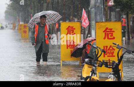 210720 -- LANZHOU, 20. Juli 2021 -- Mitarbeiter richteten Warnschilder in einem wasserdurchfluteten Gebiet im Wuzhi County in der zentralchinesischen Provinz Henan am 20. Juli 2021 ein. Das Wuzhi County von Jiaozuo hat vor kurzem ständig Regenfälle erlebt. Hochwasserschutzmaßnahmen wie Wasserentwässerung, Patrouillierungen von Böschungen und Verkehrskontrollen wurden durchgeführt, um die Sicherheit von Menschenleben und Eigentum zu schützen. Foto von /Xinhua CHINA-HENAN-WUZHI-SCHWERER REGEN CN FengxXiaomin PUBLICATIONxNOTxINxCHN Stockfoto