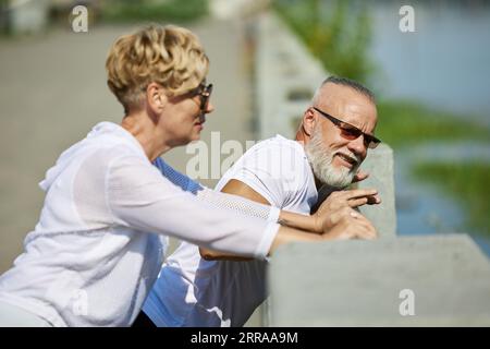 Reife, stilvolle Menschen, die im Freien trainieren, laufen, dehnen und sich um den Körper kümmern Stockfoto