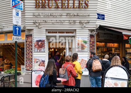 Brüssel, Belgien - Juni 27 2023: Das Geschäft, das belgische Waffeln verkauft, in dem Touristen auf Waffeln warten Stockfoto