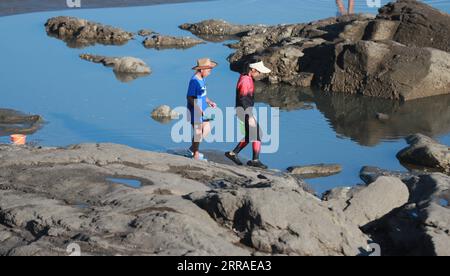 210727 -- DANDONG, 27. Juli 2021 -- Touristen spielen am Strand der Insel Zhangdao, Stadt Dandong, Provinz Liaoning im Nordosten Chinas, 26. Juli 2021. Die Insel Zhangdao, deren Bewohner vom Tourismus, der Aquakultur und der Meeresfischerei abhängig sind, zieht zahlreiche Touristen an, die sie während der Sommerferien besuchen möchten. CHINA-LIAONING-DANDONG-INSELLANDSCHAFT CN YANGXQING PUBLICATIONXNOTXINXCHN Stockfoto