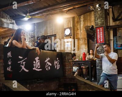 210730 -- CHONGQING, 30. Juli 2021 -- Eine Frau posiert für ein Foto beim Besuch des Communications Teahouse im südwestchinesischen Chongqing, 26. Juli 2021. Chen Anjian, 62, Lehrerin für Ölmalerei am Sichuan Fine Arts Institute, besucht seit über 20 Jahren das Chongqing Communications Teahouse. Das 1987 gegründete Communications Teahouse ist heute das einzige alte Teehaus in Chongqing, das den ursprünglichen Stil der 1970er und 80er Jahre beibehalten hat Es ist eines der wichtigsten kulturellen Wahrzeichen von Chongqing und wird täglich von Tausenden von Teeliebhabern besucht. Das Kommunikations-Teehaus ist der lebende Raum Stockfoto