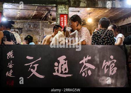210730 -- CHONGQING, 30. Juli 2021 -- Menschen unterhalten sich beim Teetrinken im Communications Teahouse im südwestchinesischen Chongqing, 26. Juli 2021. Chen Anjian, 62, Lehrerin für Ölmalerei am Sichuan Fine Arts Institute, besucht seit über 20 Jahren das Chongqing Communications Teahouse. Das 1987 gegründete Communications Teahouse ist heute das einzige alte Teehaus in Chongqing, das den ursprünglichen Stil der 1970er und 80er Jahre beibehalten hat Es ist eines der wichtigsten kulturellen Wahrzeichen von Chongqing und wird täglich von Tausenden von Teeliebhabern besucht. Das Communications Teahouse ist der Wohnraum von CH Stockfoto