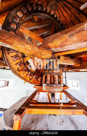 Rudimentäre Holz- und Steinmaschinen, die aus einer alten Windmühle, die als Museum in Spanien ausgestellt ist, gemahlen werden Stockfoto