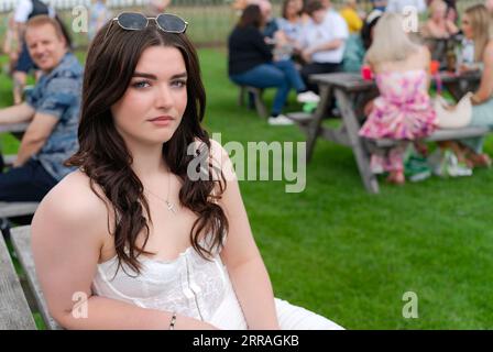 Ehrliches Porträt einer schönen Frau in modischer Kleidung genießt den Ladies Day bei den Rennen in Beverley, Großbritannien. Stockfoto
