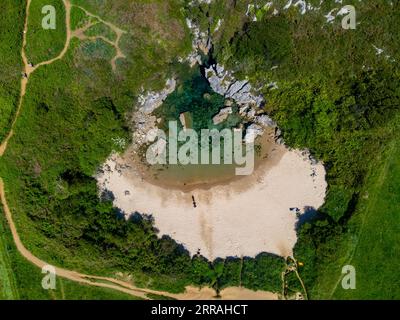 Luftaufnahme auf die kleine Playa de Gulpiyuri, überflutetes Sinkloch mit Binnenstrand in der Nähe von Llanes, in Asturien Nordspanien, rund 100 m vom Kantabrischen Meer, Stockfoto