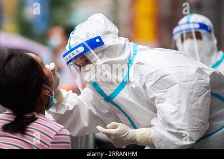 210810 -- ZHANGJIAJIE, 10. August 2021 -- Eine medizinische Fachkraft nimmt eine Abstrichprobe von einer Frau für COVID-19-Nukleinsäuretests in Zhangjiajie, zentralchinesische Provinz Hunan, 10. August 2021. Seit dem jüngsten Wiederauftreten von COVID-19 in Zhangjiajie im Juli 29 hat die Stadt 53 lokal übertragene bestätigte Fälle gemeldet, und drei asymptomatische Träger werden derzeit medizinisch beobachtet. CHINA-HUNAN-ZHANGJIAJIE-COVID-19-MASSENTESTS CN CHENXSIHAN PUBLICATIONXNOTXINXCHN Stockfoto