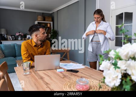 Junges freiberufliches Business-Paar, das von zu Hause aus arbeitet und Videogespräche mit Kunden auf Laptop-Webcam mit formellem Anzug und Kasua vorbereitet Stockfoto