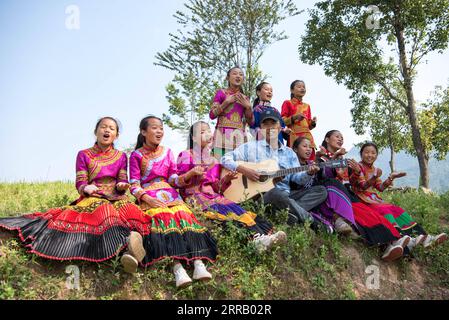210823 -- CHENGDU, 23. August 2021 -- Mädchen und ihre Lehrerin singen im Freien in der Stadt Dacao im Puge County, Autonome Präfektur Liangshan Yi, Provinz Sichuan im Südwesten Chinas, 6. August 2021. Der Mädchenchor an der zentralen Grundschule in Dacao im Puge County erlangte große Aufmerksamkeit, nachdem die Videos ihrer Auftritte auf kurzen Videoplattformen geteilt wurden. Der Chor wurde zu einem Musikfestival in Peking, der Hauptstadt Chinas, in diesem Sommer eingeladen. CHINA-SICHUAN-LIANGSHAN-MÄDCHENCHOR CN XUXBINGJIE PUBLICATIONXNOTXINXCHN Stockfoto