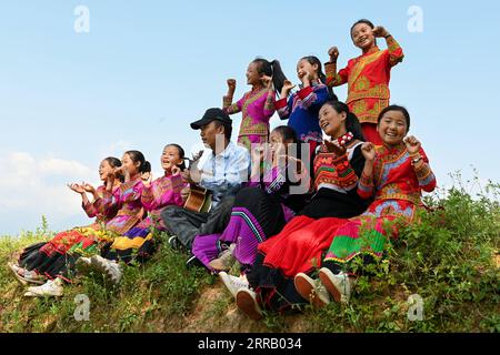 210823 -- CHENGDU, 23. August 2021 -- Mädchen und ihre Lehrerin singen im Freien in der Stadt Dacao im Puge County, Autonome Präfektur Liangshan Yi, Provinz Sichuan im Südwesten Chinas, 6. August 2021. Der Mädchenchor an der zentralen Grundschule in Dacao im Puge County erlangte große Aufmerksamkeit, nachdem die Videos ihrer Auftritte auf kurzen Videoplattformen geteilt wurden. Der Chor wurde zu einem Musikfestival in Peking, der Hauptstadt Chinas, in diesem Sommer eingeladen. CHINA-SICHUAN-LIANGSHAN-MÄDCHENCHOR CN TANGXWENHAO PUBLICATIONXNOTXINXCHN Stockfoto