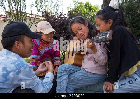 210823 -- CHENGDU, 23. August 2021 -- Ein Mädchen übt Gitarre an der zentralen Grundschule von Dacao im Puge County, Autonome Präfektur Liangshan Yi, Provinz Sichuan im Südwesten Chinas, 6. August 2021. Der Mädchenchor an der zentralen Grundschule in Dacao im Puge County erlangte große Aufmerksamkeit, nachdem die Videos ihrer Auftritte auf kurzen Videoplattformen geteilt wurden. Der Chor wurde zu einem Musikfestival in Peking, der Hauptstadt Chinas, in diesem Sommer eingeladen. CHINA-SICHUAN-LIANGSHAN-MÄDCHENCHOR CN TANGXWENHAO PUBLICATIONXNOTXINXCHN Stockfoto