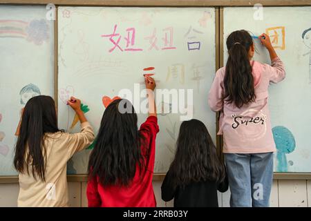 210823 -- CHENGDU, 23. Aug. 2021 -- Mitglieder eines Kinderchores malen den Namen des Chors in der zentralen Grundschule Dacao im Puge County, Autonome Präfektur Liangshan Yi, Provinz Sichuan im Südwesten Chinas, 4. Aug. 2021. Der Mädchenchor an der zentralen Grundschule in Dacao im Puge County erlangte große Aufmerksamkeit, nachdem die Videos ihrer Auftritte auf kurzen Videoplattformen geteilt wurden. Der Chor wurde zu einem Musikfestival in Peking, der Hauptstadt Chinas, in diesem Sommer eingeladen. CHINA-SICHUAN-LIANGSHAN-MÄDCHENCHOR CN XUXBINGJIE PUBLICATIONXNOTXINXCHN Stockfoto