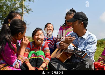 210823 -- CHENGDU, 23. August 2021 -- Mädchen und ihre Lehrer spielen im Freien in Dacao Town of Puge County, Autonome Präfektur Liangshan Yi, südwestchinesische Provinz Sichuan, 6. August 2021. Der Mädchenchor an der zentralen Grundschule in Dacao im Puge County erlangte große Aufmerksamkeit, nachdem die Videos ihrer Auftritte auf kurzen Videoplattformen geteilt wurden. Der Chor wurde zu einem Musikfestival in Peking, der Hauptstadt Chinas, in diesem Sommer eingeladen. CHINA-SICHUAN-LIANGSHAN-MÄDCHENCHOR CN TANGXWENHAO PUBLICATIONXNOTXINXCHN Stockfoto