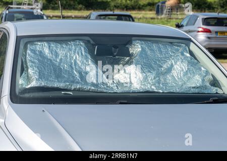 Ein Auto Sonnenschutz für die Windschutzscheibe die Wärme aus einem Auto zu  halten, wenn geparkt. Im Schatten von der Sonne, Schutz vor UV-Strahlung  und Hitze Stockfotografie - Alamy