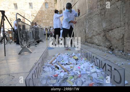 210825 -- JERUSALEM, 25. August 2021 -- Mitarbeiter entfernen am 25. August 2021 handschriftliche Notizen zwischen den alten Steinen der Westmauer in der Altstadt von Jerusalem. Der Prozess zur Entfernung von Notizen von der Westmauer findet zweimal im Jahr vor dem jüdischen Neujahr und dem Passahfest statt. Foto von /Xinhua MIDEAST-JERUSALEM-Western WALL-NOTE-ENTFERNUNG MuammarxAwad PUBLICATIONxNOTxINxCHN Stockfoto