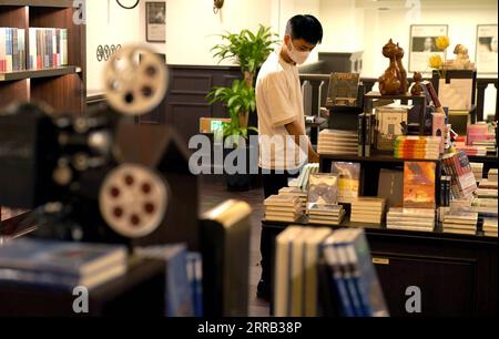 210829 -- XI AN, 29. August 2021 -- Ein Mann schlendert im Bell Tower Bookstore in Xi an, nordwestchinesische Provinz Shaanxi, 25. August 2021. Der Bell Tower Bookstore wurde 1955 als erste staatliche Buchhandlung in Xi an erbaut und war als kulturelles Wahrzeichen der Stadt bekannt. Um das kulturelle Erbe zu schützen, wurde 2008 der Buchladen an einen anderen Ort verlegt. Vor kurzem wurde der Bell Tower Bookstore nach der Instandhaltung wieder an seine ursprüngliche Stelle gebracht, wodurch sein ursprüngliches Aussehen in den 1950er Jahren im Wesentlichen wiederhergestellt wurde, so dass Bürger und Touristen die historische und kulturelle kultur wieder erleben können Stockfoto