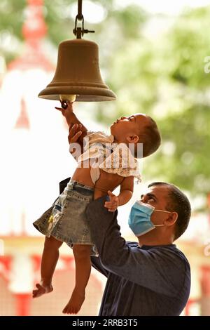 210830 -- DHAKA, 30. August 2021 -- Ein Baby klingelt mit Hilfe ihres Vaters in einem Tempel anlässlich des Janmashtami in Dhaka, Bangladesch, 30. August 2021. Janmashtami ist ein jährliches Festival, das den Geburtstag des hinduistischen Gottes Krishna feiert. BANGLDESH-DHAKA-HINDU-FESTIVAL Salim PUBLICATIONxNOTxINxCHN Stockfoto