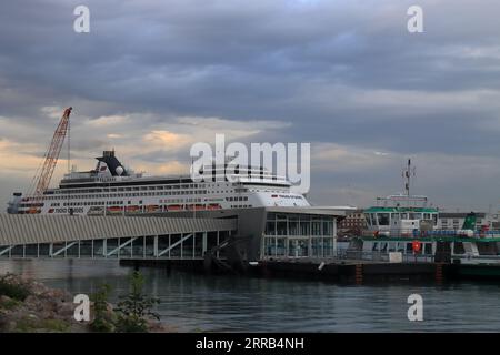 Riesiges Kreuzfahrtschiff, das über der Gosport-Fähre und dem Ponton ragt. Vasco da Gama ist ein Kreuzfahrtschiff der S-Klasse, das von Mystic Invest und Nicko Cruises betrieben wird. Frühere Namen sind Statendam und Pacific Eden. Sie ist derzeit im portugiesischen Hafen Madeira registriert und nach dem portugiesischen Entdecker benannt. Das Schiff verfügt über 14 Decks und kann 1258 Passagiere und 557 Besatzungen befördern. Stockfoto