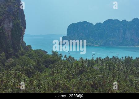 Felsen und Kokosnussbaumhaine auf der Railay Peninsula, ein Blick vom Railay Viewpoint, sowie Langboot fahren von Ao Nang nach Railay West Beach Stockfoto