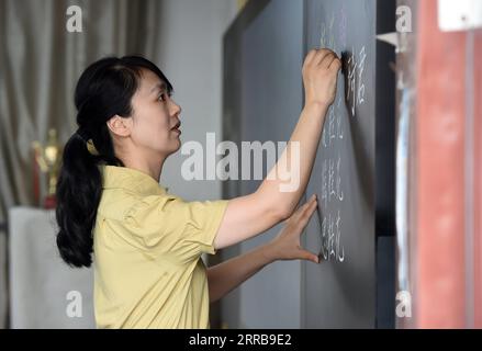 210909 -- HEFEI, 9. September 2021 -- Zhao Xun gibt einen Chinakurs an der Luogang Primary School in Hefei, Ostchinesische Provinz Anhui, 8. September 2021. Zhao Xun, eine Chinesischlehrerin der Luogang Primary School, auch Strickliebhaberin, gründet einen Strickclub und unterrichtet ihre Schüler während der Nachschulzeit in Handarbeit stricken. CHINA-ANHUI-HEFEI-AFTER-SCHOOL-AKTIVITÄT CN ZHOUXMU PUBLICATIONXNOTXINXCHN Stockfoto