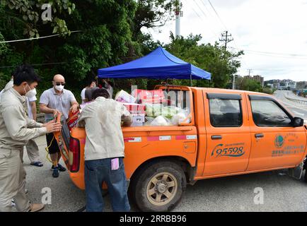 210912 -- XIANYOU, 12. September 2021 -- Mitarbeiter des State Grid übertragen Lieferungen in den Sperrbereich im Xianyou County, ostchinesische Provinz Fujian, 12. September 2021. Xianyou County in der ostchinesischen Provinz Fujian hat Fengting Town als ein COVID-19-Hochrisikogebiet eingestuft, nachdem neue lokale Infektionen gemeldet wurden. Seit dem 10. September hat Fujian 21 lokal übertragene bestätigte COVID-19-Fälle gemeldet, hauptsächlich im Xianyou County. CHINA-FUJIAN-XIANYOU-COVID-19-CONTROL WeixPeiquan PUBLICATIONxNOTxINxCHN Stockfoto