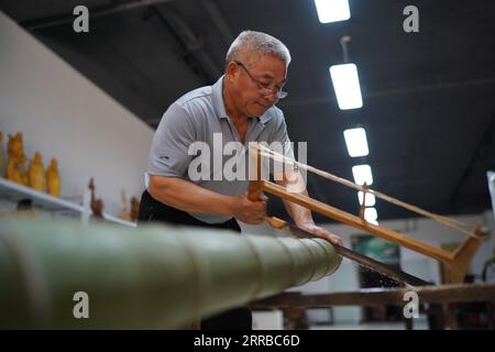 210914 -- XINYU, 14. September 2021 -- Li Nian Gen bereitet Rohmaterial für seine Bambusprodukte in der Dongcun Township, Fenyi County, Xinyu Stadt der ostchinesischen Provinz Jiangxi, 2. September 2021 vor. Li Nian Gen, 62, ist der Erben der Bambusweberei in der fünften Generation in der Dongcun-Gemeinde. Li erwarb Bambus-Webtechniken von seinem Onkel, als er gerade einmal neun Jahre alt war, und begann mit 15 Jahren seinen Lebensunterhalt auf eigene Faust zu verdienen. Mehr als 20 seiner Auszubildenden entschieden sich Anfang der 1990er Jahre, eine Beschäftigung zu suchen, um ein besseres Einkommen in anderen Lebensbereichen außerhalb des Heimatlandes zu erzielen, aber Li entschied sich, zu bleiben und sich daran zu halten Stockfoto