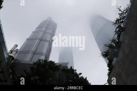 210914 -- SHANGHAI, 14. September 2021 -- Foto aufgenommen am 13. September 2021 zeigt Wolkenkratzer in Lujiazui im ostchinesischen Shanghai. Chanthu, der 14. Taifun des Jahres, soll von Montagnacht bis Mittwoch zwischen 100 km und 200 km östlich von Shanghai über dem Meer verweilen, bevor er am Donnerstag schwächer werde und sich nordöstlich von der Stadt entferne, sagte das meteorologische Zentrum von Shanghai. Dämpfer, eine spezielle Windschutzvorrichtung, kann eine Reaktionskraft gegen die Massenträgheit des Wolkenkratzers erzeugen, die durch den Taifun beeinflusst wird. Die Schwingungen des Gebäudes werden durch die Bewegung des Dämpfers ausgeglichen Stockfoto