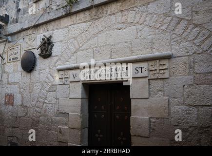 Fünfte Station des Kreuzes auf der Via Dolorosa, Jerusalem mit der Aufschrift „ein Kreuz ist auf Simon Cyrenaeus gesetzt“ Stockfoto