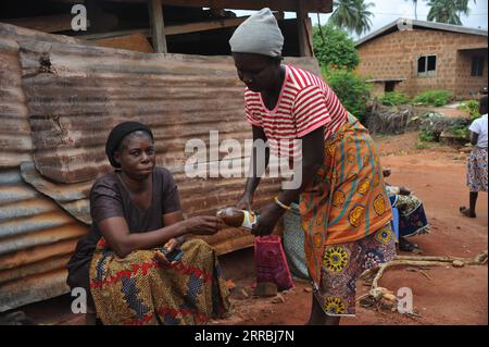 210925 -- ACCRA, 25. September 2021 -- Ein Arbeiter gießt Noni-Saft, der von einer lokalen Firma für eine Frau in Dodome, Volta Region, Ghana, 10. September 2021 hergestellt wird. Lokale Unternehmen spenden kostenlose organische Insektenschutzmittel an die Einheimischen, einige für das Abwischen auf dem Körper und andere für das Brennen in ihren Räumen, um Angriffe von den Phlebotominen Sandfliegen abzuwehren, die schwere Hautläsionen und parasitäre Leishmaniasis-Infektionen verursachen können. Außerdem spenden sie zertifizierte Nahrungsergänzungsmittel, die aus der Noni-Pflanze hergestellt werden, an die Einheimischen als Immunverstärker gegen Infektionen durch Insektenstiche. ZU DEN Funktionen: Ghanaian Farming com Stockfoto