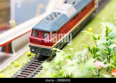 Eisenbahnmodellierung. Nahaufnahme des Modellzugs auf den Schienen Stockfoto