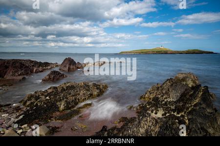 Felsküste aus Bellycotton mit Leuchtturm für die Meeressicherheit in Irland. Stockfoto