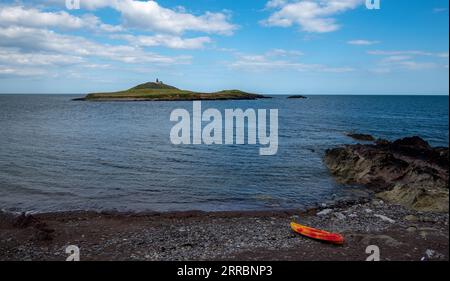 Felsküste aus Bellycotton mit Leuchtturm für die Meeressicherheit in Irland. Stockfoto