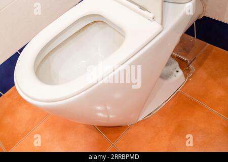 Die alte Toilettenschüssel wurde auf dem Boden mit Keramikfliesen entfernt Stockfoto