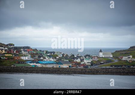 Das Dorf EI∂i auf den Färöern auf der Insel Eysturoy, von der anderen Seite des Fjords aus gesehen. Stockfoto