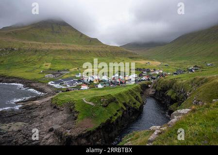 Das kleine Dorf Gjogv und seine Kirche bevölkern das Meer an der nordöstlichen Ecke der Insel Eysturoy auf den Färöern. Stockfoto