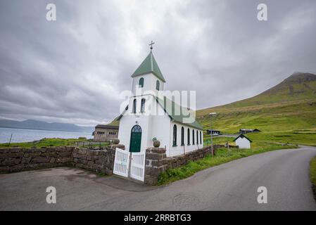 Das kleine Dorf Gjogv und seine Kirche aus dem Jahr 1929 bevölkern das Meer an der nordöstlichen Ecke der Insel Eysturoy auf den Färöern. Stockfoto