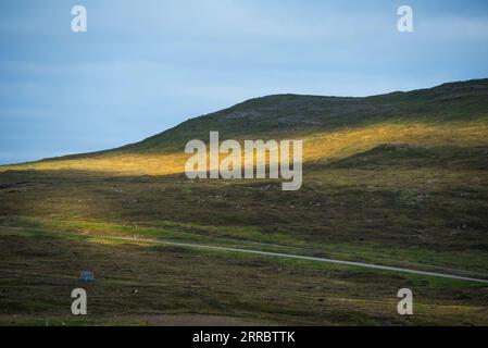 Das Nachmittagslicht taucht auf der Insel Vagar auf den Färöern auf einem abgelegenen Berghang in gedämpftes Licht. Stockfoto