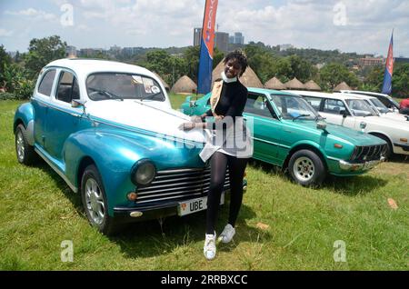 211010 -- KAMPALA, 10. Oktober 2021 -- Eine Frau posiert für Fotos bei der Independence Day Vintage Car Show in Kampala, Uganda, 9. Oktober 2021. Über 70 Fahrzeuge wurden am Samstag während der Veranstaltung gezeigt. Foto von /Xinhua UGANDA-KAMPALA-CAR SHOW NicholasxKajoba PUBLICATIONxNOTxINxCHN Stockfoto