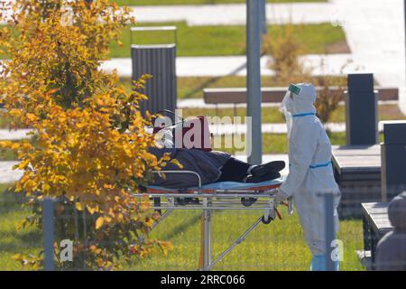 211011 -- MOSKAU, 11. Oktober 2021 -- Ein medizinischer Arbeiter, Der Schutzkleidung trägt, überführt einen Patienten von einem Krankenwagen in ein Krankenhaus in Kommunarka außerhalb von Moskau, Russland, 11. Oktober 2021. Russland registrierte in den letzten 24 Stunden 29.409 neue Coronavirus-Fälle, die höchste Zahl in diesem Jahr, womit die landesweite Zahl auf 7.804.774 gestiegen ist, sagte das offizielle Überwachungs- und Reaktionszentrum am Montag. Foto von /Xinhua RUSSIA-MOSCOW-COVID-19-CASES AlexanderxZemlianichenkoxJr PUBLICATIONxNOTxINxCHN Stockfoto